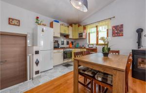 a kitchen with a table and a white refrigerator at Cozy Home In Slivnica in Slivnica