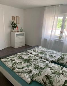 a bedroom with a bed with a green and white comforter at Ferienwohnung König in Schnaittenbach +6 photos