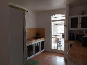 a kitchen with a door leading to a balcony at Baboo Apartment in Coteau Raffin