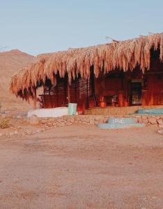 una cabaña con techo de paja en el desierto en Anne Sinai best camp, en Nuweiba