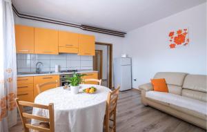 a living room with a table and a kitchen and a couch at Beautiful Home In Peruski With Kitchen in Peruški