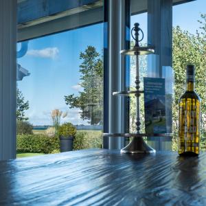 a bottle of wine on a table in front of a window at Mein-Ostseeplätzchen Haus am Meer 9 in Niesgrau +17 photos
