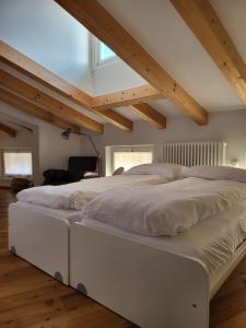 a large white bed in a room with wooden ceilings at La Casa dei Turchi in Rovereto +76 photos