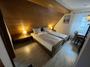 a bedroom with a bed and a wooden wall at Gästehaus Goldenes Lamm in Rothenburg ob der Tauber