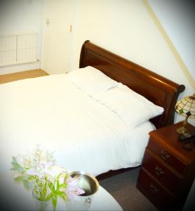 a bed with a white comforter and pillows at Tayview Hotel in Dundee