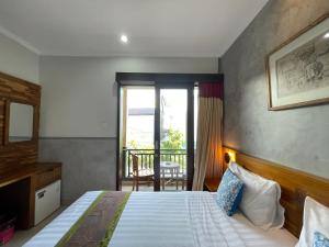 una habitación de hotel con una cama y un balcón en Kubu Indah Homestay Sanur, en Sanur