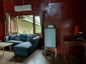 a living room with a couch and a refrigerator at Teak@Teak in Ban Cha-om
