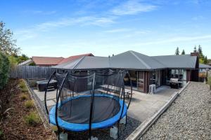 una casa con un trampolín en el patio en Happy Hanmer - Hanmer Springs Holiday Home, en Hanmer Springs