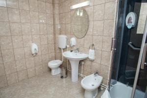 a bathroom with a sink and a toilet and a shower at Sin-Kom Hotel Garni in Pirot