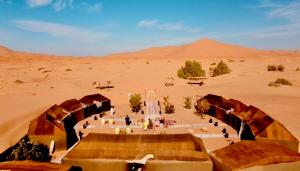 a group of people standing in the desert at Eco Merzouga luxury camp in Merzouga