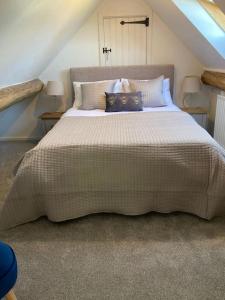 a bedroom with a large bed with pillows on it at Luxury cottage with Hot Tub in Fenny Compton