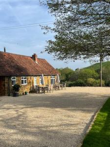 a house with tables and chairs in front of it at Luxury cottage with Hot Tub in Fenny Compton +19 photos