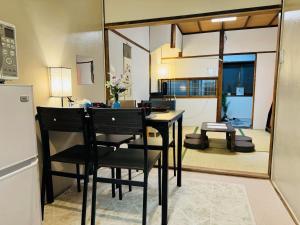 a dining room with a table and chairs and a mirror at 9人可能 黒門市場 けんちハウス in Osaka
