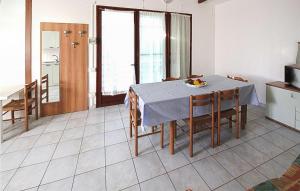 a kitchen and dining room with a table and chairs at Lovely Apartment In Rosolina Mare in Rosolina Mare +12 photos