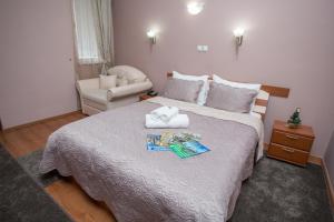 a bedroom with a large bed and a chair at Sin-Kom Hotel Garni in Pirot