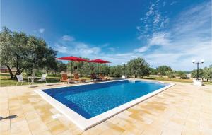 une piscine avec chaises et parasols dans une cour dans l'établissement Apartment Peroj Ii, à Vodnjan