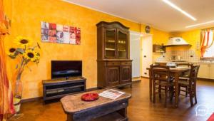 a living room with a kitchen and a table with chairs at Wallace Apartment in Aosta
