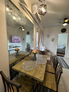 een eetkamer met houten tafels en stoelen bij Cozy Condo Almond drive 1BR Talisay SRP w pool in Tangke