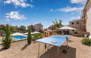 a ping pong table in a backyard with a pool at 2 Bedroom Pet Friendly Home In Brzac in Brzac