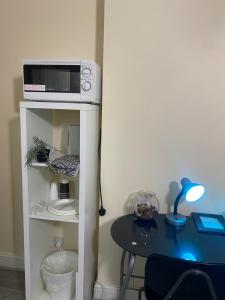 a small table with a microwave on top of a cabinet at Neil2 in London