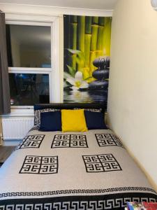 a bedroom with a bed with a painting on the wall at Neil2 in London