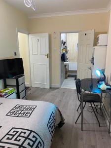 a bedroom with a bed and a table and a kitchen at Neil2 in London
