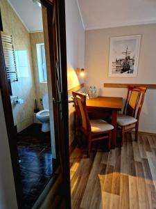 a room with a table and chairs and a bathroom at Willa Bliska in Gdańsk