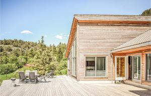 una terrazza in legno con sedie e una casa di Amazing Home In Etne With Wifi a Etnesjøen