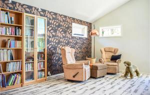 un soggiorno con 2 sedie e una libreria di Amazing Home In Etne With Wifi a Etnesjøen
