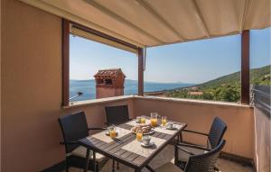 stół na balkonie z widokiem na ocean w obiekcie 3 Bedroom Cozy Apartment In Labin w mieście Ravni