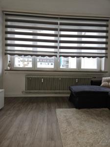 a living room with two large windows and a bed at City Base Dortmund in Dortmund