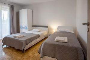 een slaapkamer met twee bedden met handdoeken erop bij Villa Sara Family Villa with Pool and Jacuzzi Imotski Makarska Region in Imotski +59 foto's