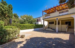 a house with a patio and a driveway at Amazing Apartment In Mandre With Wifi in Mandre