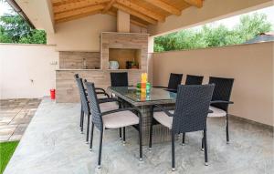 a patio with a table and chairs and a kitchen at 2 Bedroom Nice Apartment In Medulin in Medulin