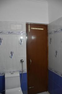 a bathroom with a toilet and a wooden door at Hotel Sunrise in Chandīgarh
