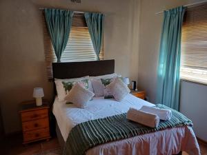 a bedroom with a large bed with blue curtains at Susanna's Self catering 2 bedroom apartment in Kimberley