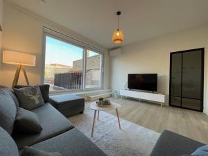 a living room with a couch and a tv at Pand 43 in Diksmuide