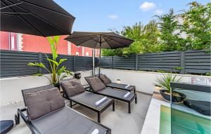 a patio with two chairs and an umbrella at Beautiful Home In Srima in Srima +51 photos