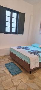 a bed in a room with a window and a rug at Paradise Hospedaria São Thomé in São Thomé das Letras +16 photos