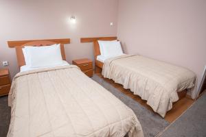 two beds in a small room withermottermottermott at Sin-Kom Hotel Garni in Pirot