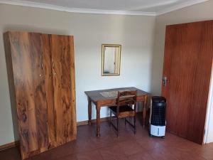 a room with a table and a wooden door at Susanna's Self catering 2 bedroom apartment in Kimberley +2 photos