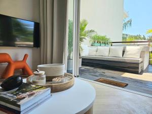 a living room with a couch and a table at Seaside 3 suites Penthouse with Pool Gym & BBQ Terrace in Cap Malheureux