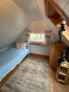 ein kleines Schlafzimmer mit einem Bett im Dachgeschoss in der Unterkunft 3 bedroom cosy cottage in Lamlash, Isle Of Arran in Lamlash