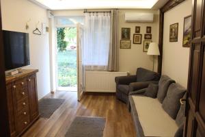 a living room with a couch and a television at Pálma Apartmanok Szálláshely Százhalombatta 3a in Százhalombatta