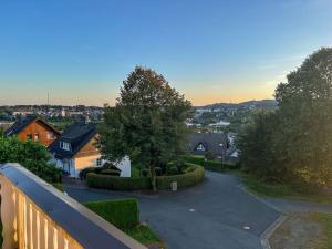 a view from a balcony of a house with a driveway at Bovenappartement in Winterberg met balkon en uitzicht over het bos in Winterberg +6 photos