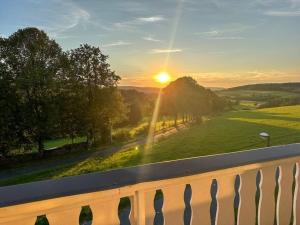 a view of the sunset from a balcony at Bovenappartement in Winterberg met balkon en uitzicht over het bos in Winterberg