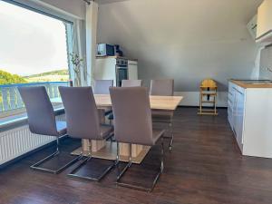 a dining room with a table and chairs and a balcony at Bovenappartement in Winterberg met balkon en uitzicht over het bos in Winterberg