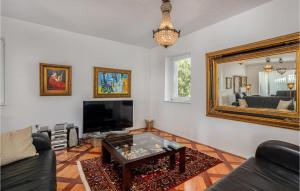 a living room with a table and a mirror at 6 Bedroom Lovely Home In Rab in Rab