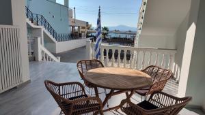 a wooden table and four chairs on a balcony at Messinian Aura in Arkondikó