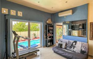 a living room with a couch and a swimming pool at 3 Bedroom Cozy Home In Koropi in Áyios Nikólaos